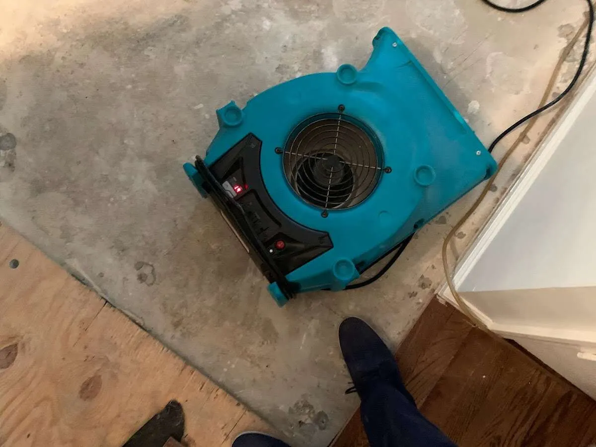 Air mover drying subfloor during Commercial Water Damage Restoration in Dallas